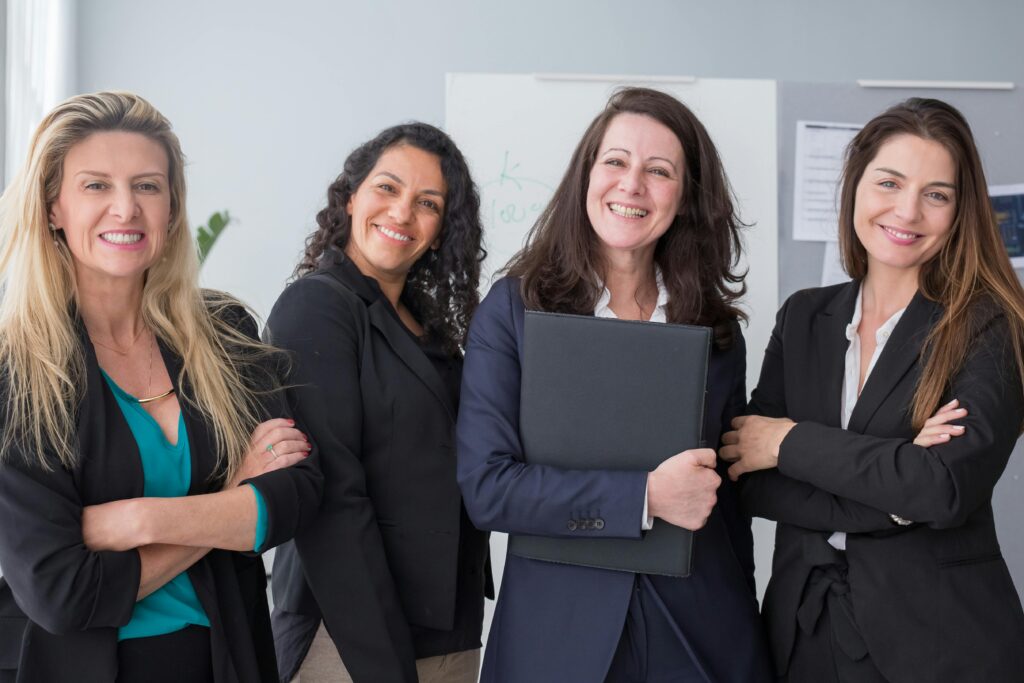 A group of diverse women entrepreneurs collaborating and smiling, representing empowerment and teamwork in business.