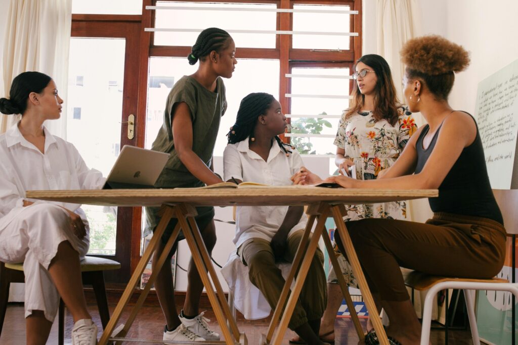 A group of diverse women entrepreneurs collaborating and smiling, representing empowerment and teamwork in business.
