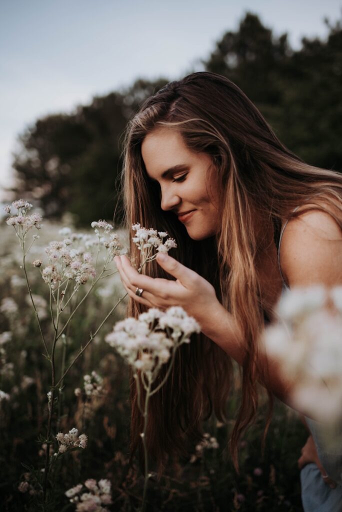 woman in white sleeveless top holding white flowers